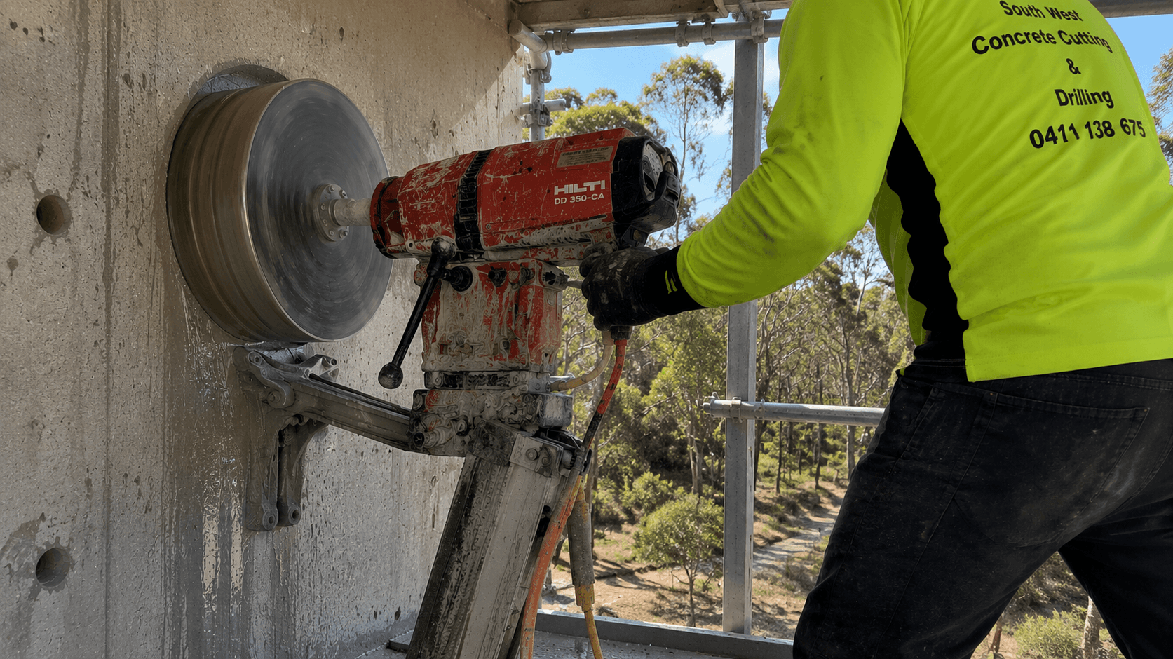 Diamond tipped concrete core drilling equipment being used on slab wall.